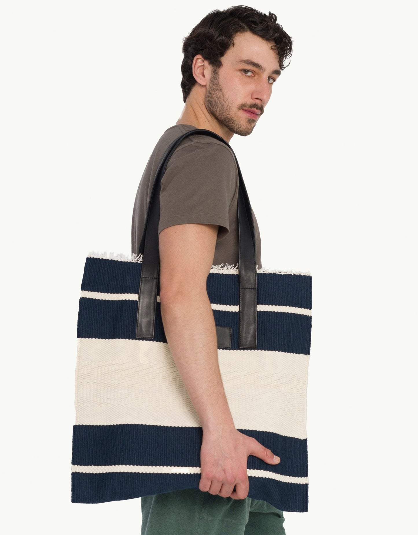 Explore our handcrafted tote bag, inspired by Peruvian artisanship. This two-tone cotton weave tote showcases naturally tanned crust cowhide and tocuyo cotton lining, complete with dual compartments and pockets for practical elegance. Browse our selection of Peruvian artisan tote bags.